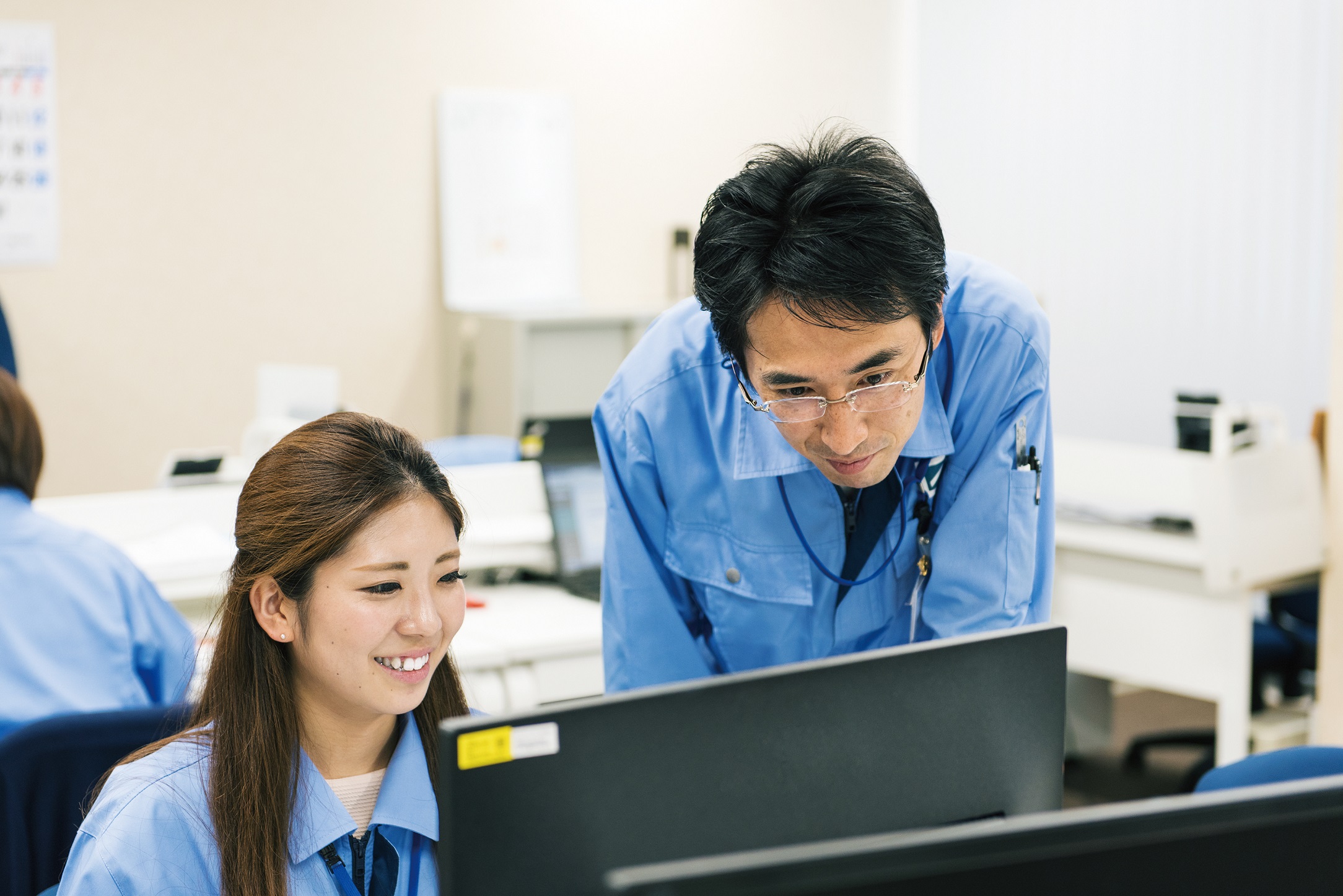 日本GLP×日研特集_教えてもらっている女性社員の画像